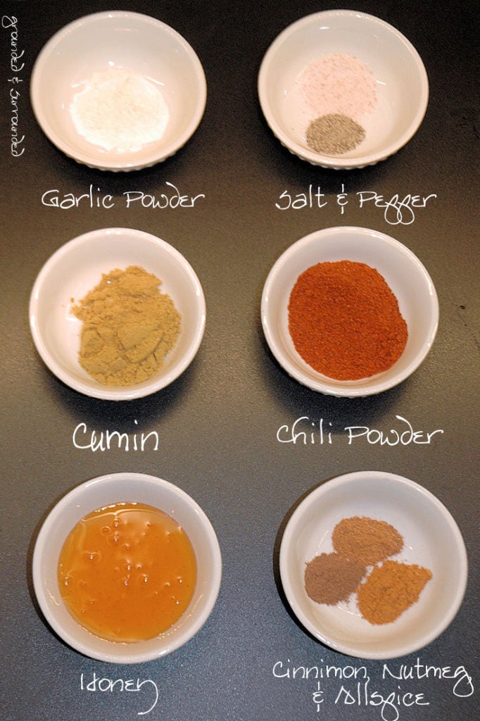 All the seasonings needed for a spicy chili recipe in white pinch bowls.