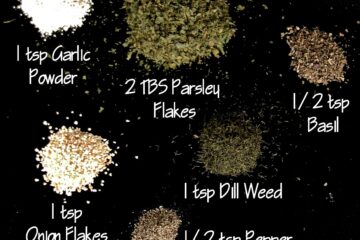 Garlic powder, parsley flakes, basil, dill weed, onion flakes, and black pepper on a black background.