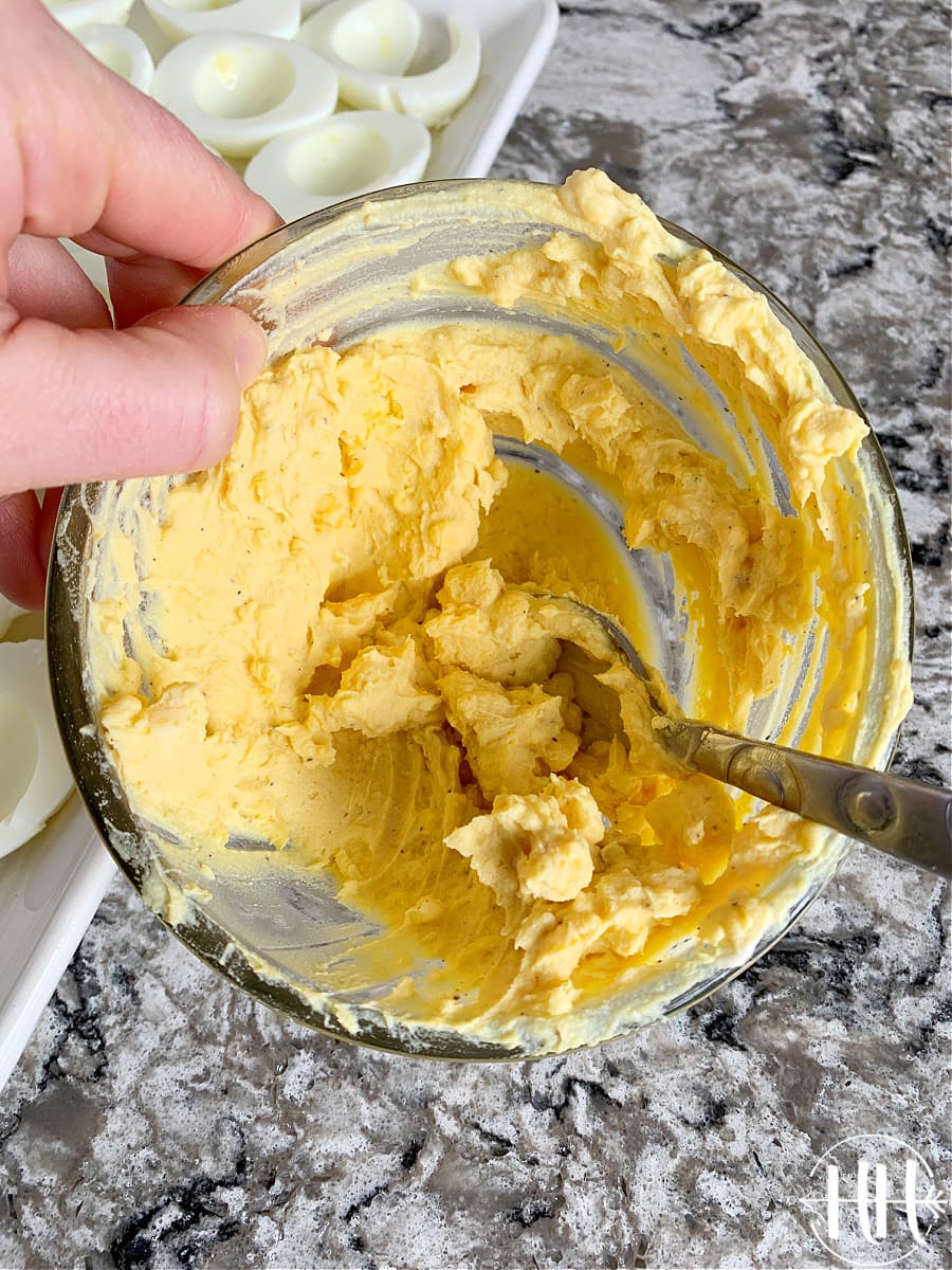 A small bowl of yellow egg yolks mixed with mayo and mustard for deviled eggs. 