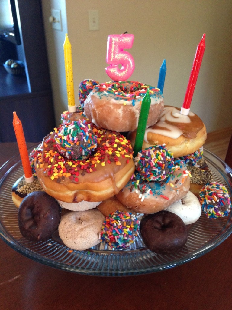 A cake made of stacked donuts for a 5th birthday. 