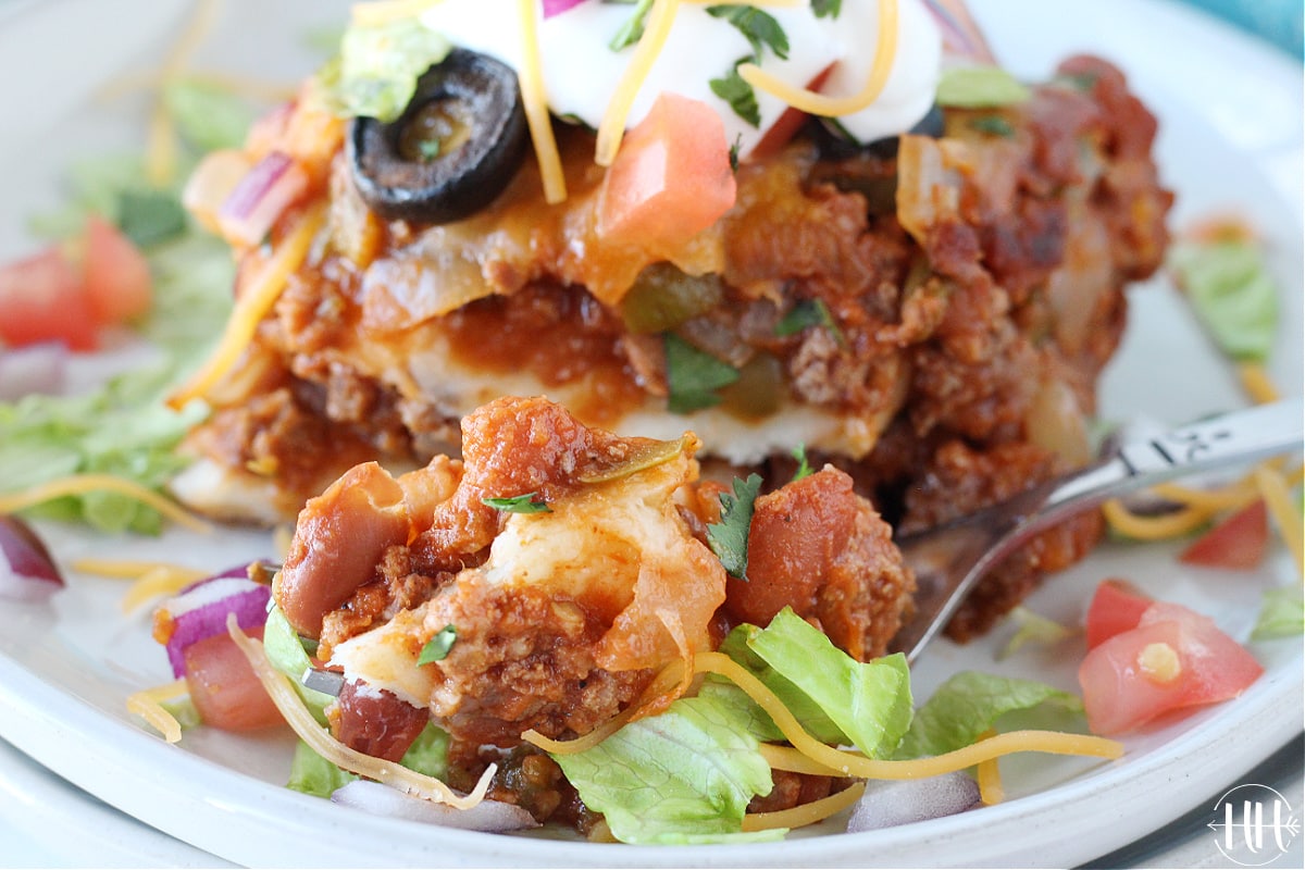 A piece of Healthy Mexican Lasagna with a large bite on a fork.