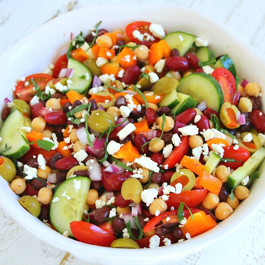 A white bowl filled with Mediterranean bean salad.