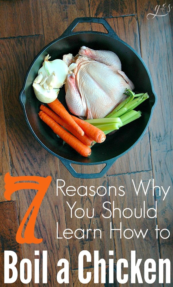 A roasting chicken in a cast iron pot with carrots, onion, and celery ready to be boiled. 