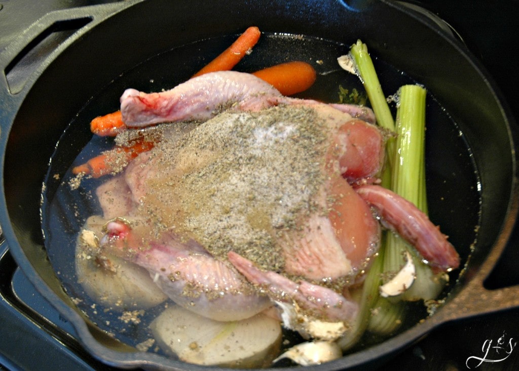 Whole chicken, vegetables, water, and seasonings ready to be boiled.