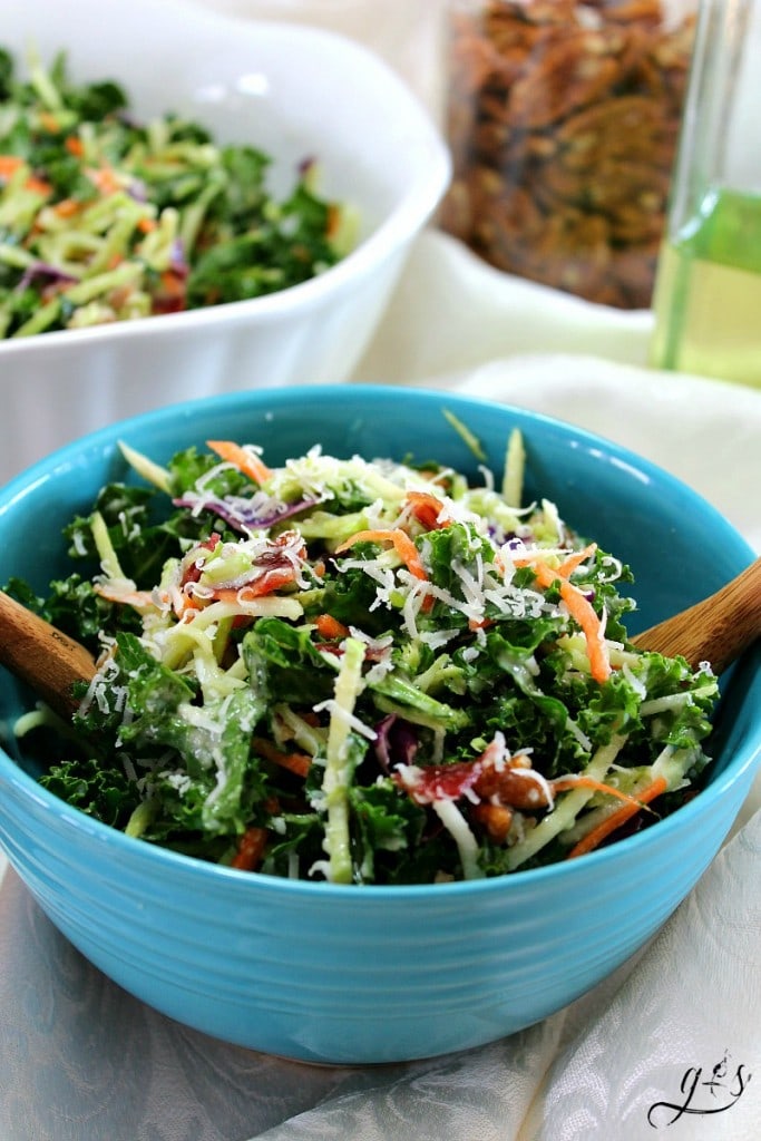Broccoli Slaw Salad ready to be served with wooden salad tongs.