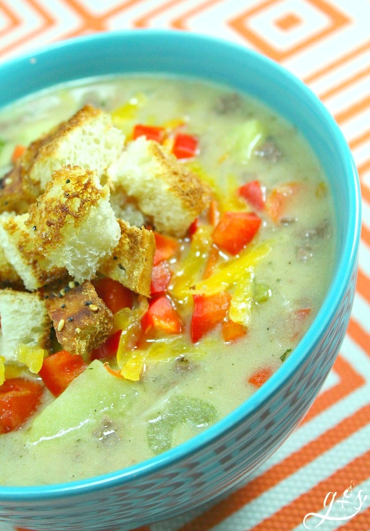 A turquoise bowl filled with Whole Foods Family Recipes: Cheeseburger Soup topped with homemade croutons.