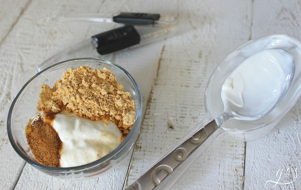 Powdered peanut butter, plain Greek yogurt, coconut sugar and vanilla in a glass bowl.