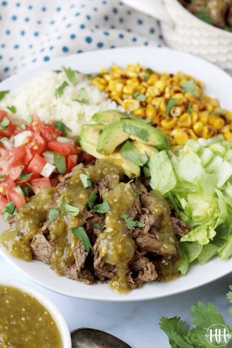 Salsa verde shredded beef roast on a salad with pico de gallo and avocado.