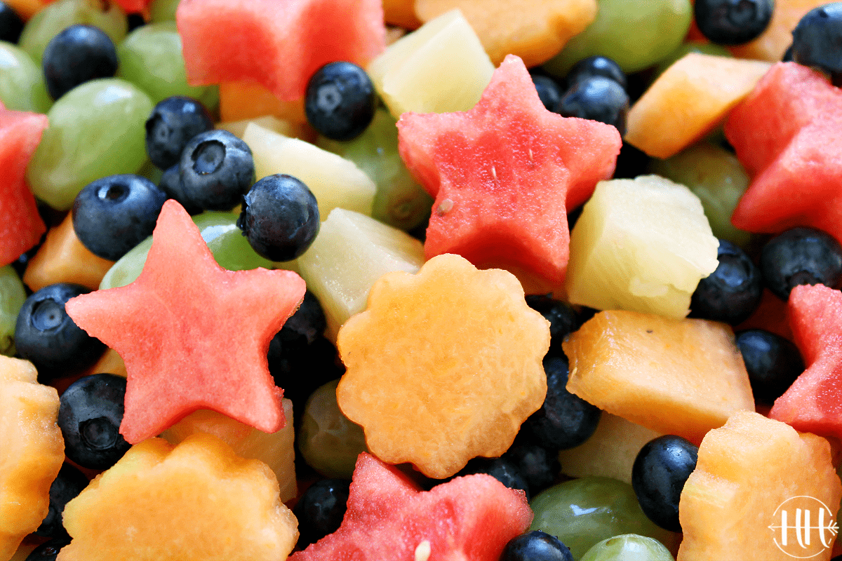 Up close view of watermelon stars, flower shaped cantaloupe and blueberries.