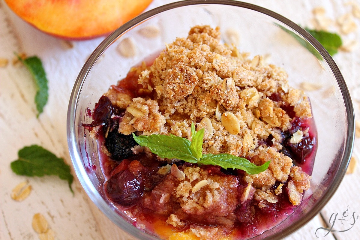 Bowl of peaches and blueberries with a crumble topping. 