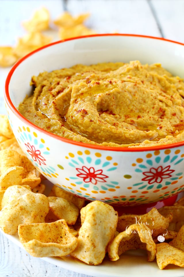 Stunning orange Pumpkin Hummus from Kim's Cravings in a white flowered bowl. 