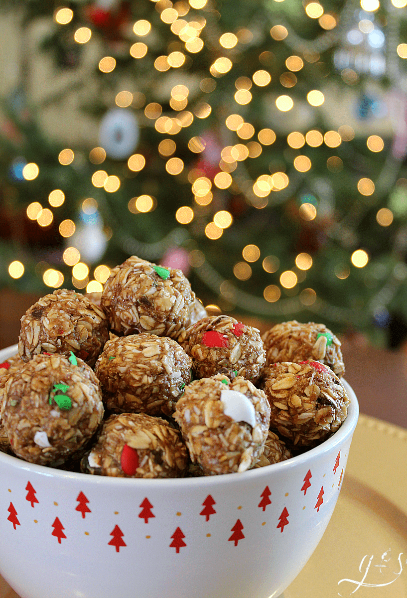 The BEST 6 Ingredient Christmas Energy Bites | This healthy no bake recipe is easy and quick to prepare. Oatmeal, flaxseed (or hemp seeds), peanut butter, M&Ms, honey, and "snow" aka finely shredded coconut make up these homemade gluten free goodies. Make these raw bites for kids and adults alike. Think monster cookie, but with 5 simple whole food ingredients!