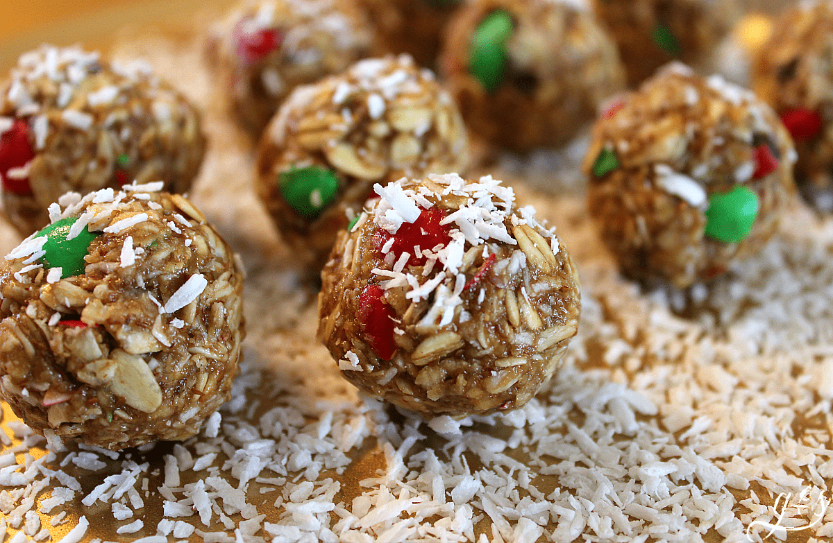 The BEST 6 Ingredient Christmas Energy Bites | This healthy no bake recipe is easy and quick to prepare. Oatmeal, flaxseed (or hemp seeds), peanut butter, M&Ms, honey, and "snow" aka finely shredded coconut make up these homemade gluten free goodies. Make these raw bites for kids and adults alike. Think monster cookie, but with 5 simple whole food ingredients!