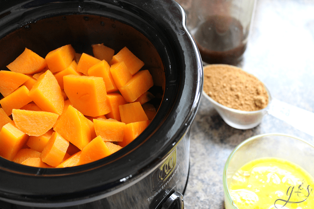 Diced and cooked sweet potatoes in a small crock pot ready to assemble casserole. 