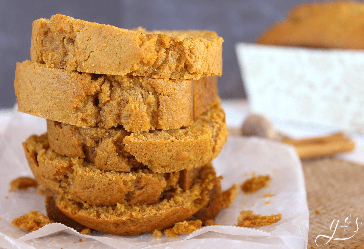 My grandma's pumpkin bread recipe made into smaller loaves, sliced, and stacked on wax paper.