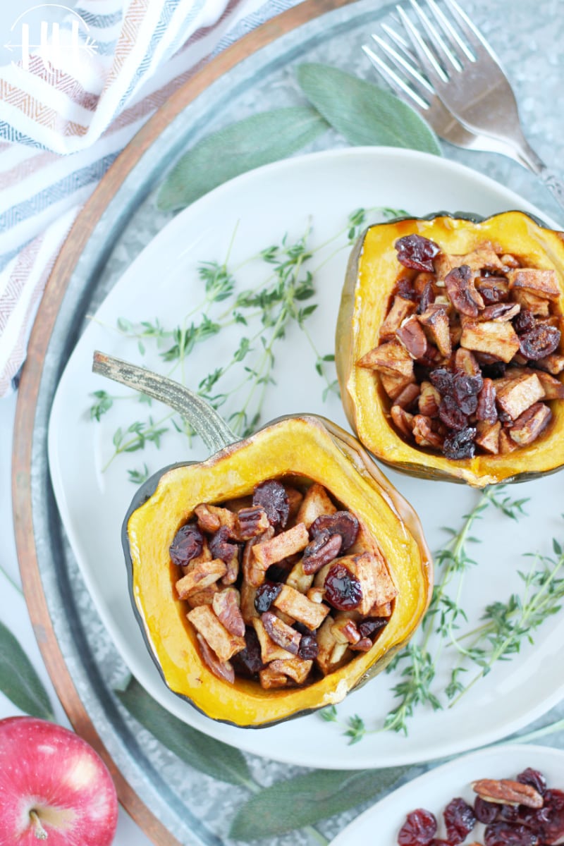 Two halves of an acorn squash stuffed with sweet maple syrup and butter fruit goodness.