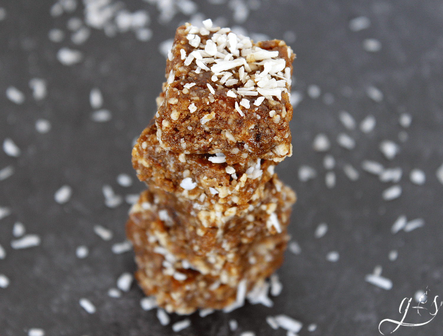 A tall stack of no bake holiday energy bites sprinkled with shredded coconut.