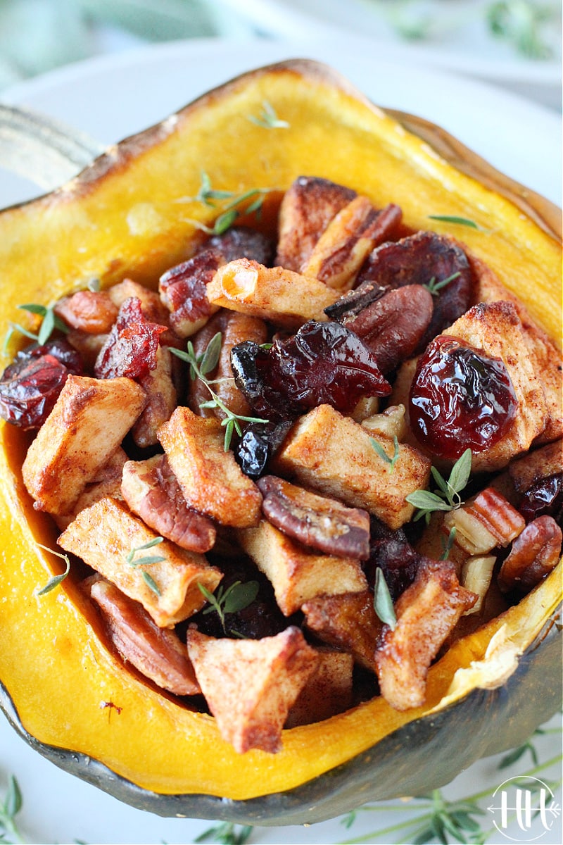 Up close shot of a Clean Eating stuffed Acorn Squash garnished with thyme.