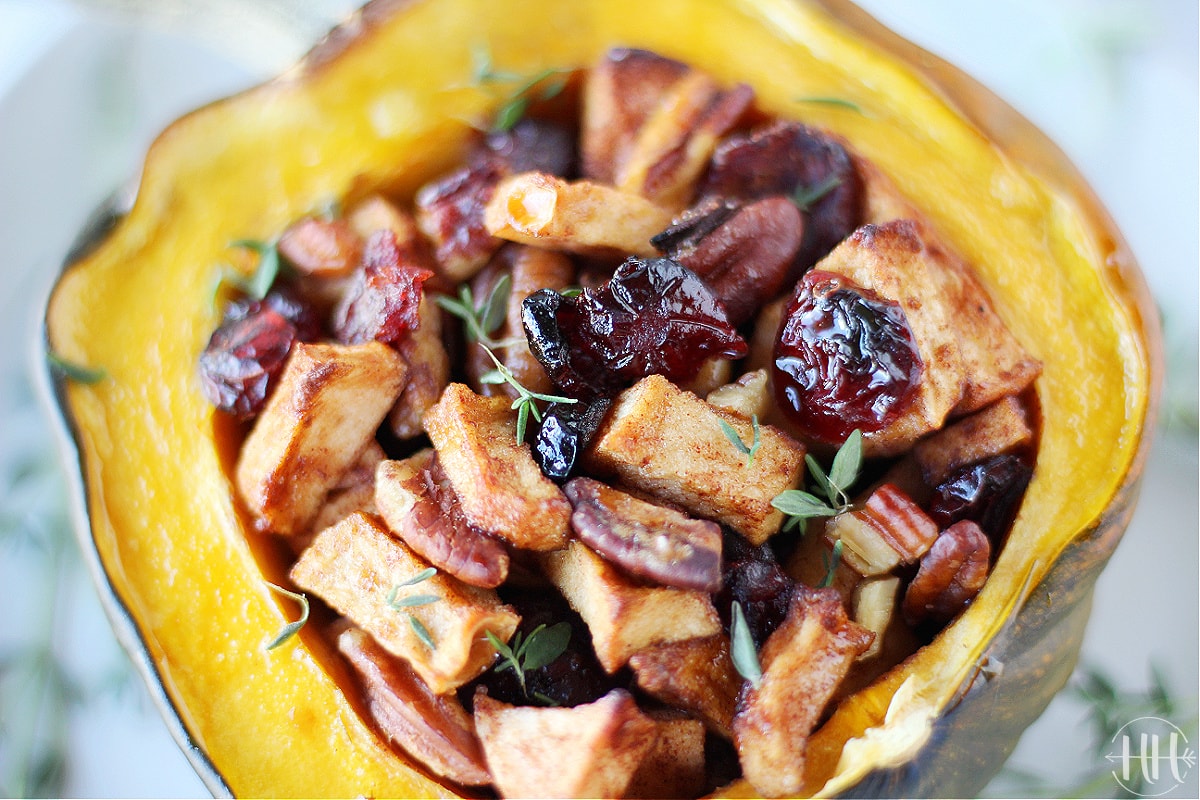Dried cranberries, diced apples, and pecans in a butter and coconut sugar sauce inside an acorn squash.