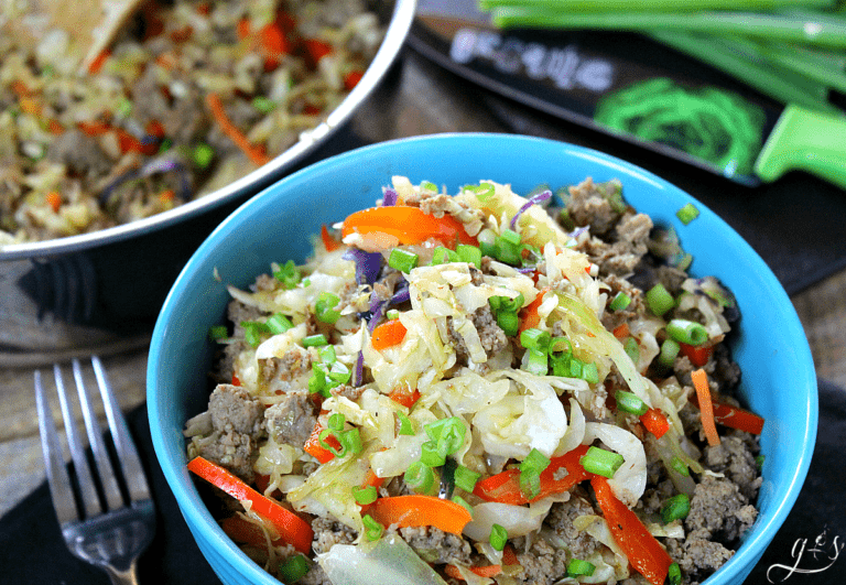 Egg roll in a bowl in a blue bowl topped with green onions.