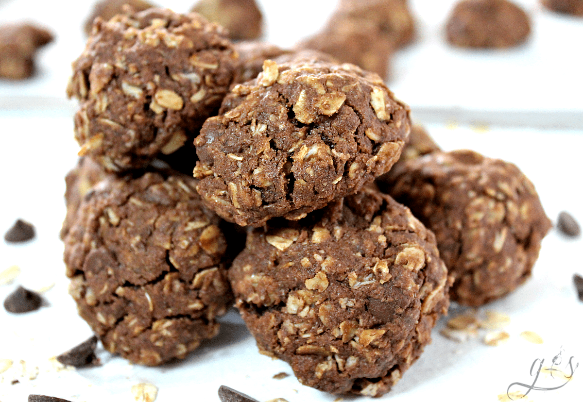 A pile of easy double chocolate oatmeal cookies on a white countertop.