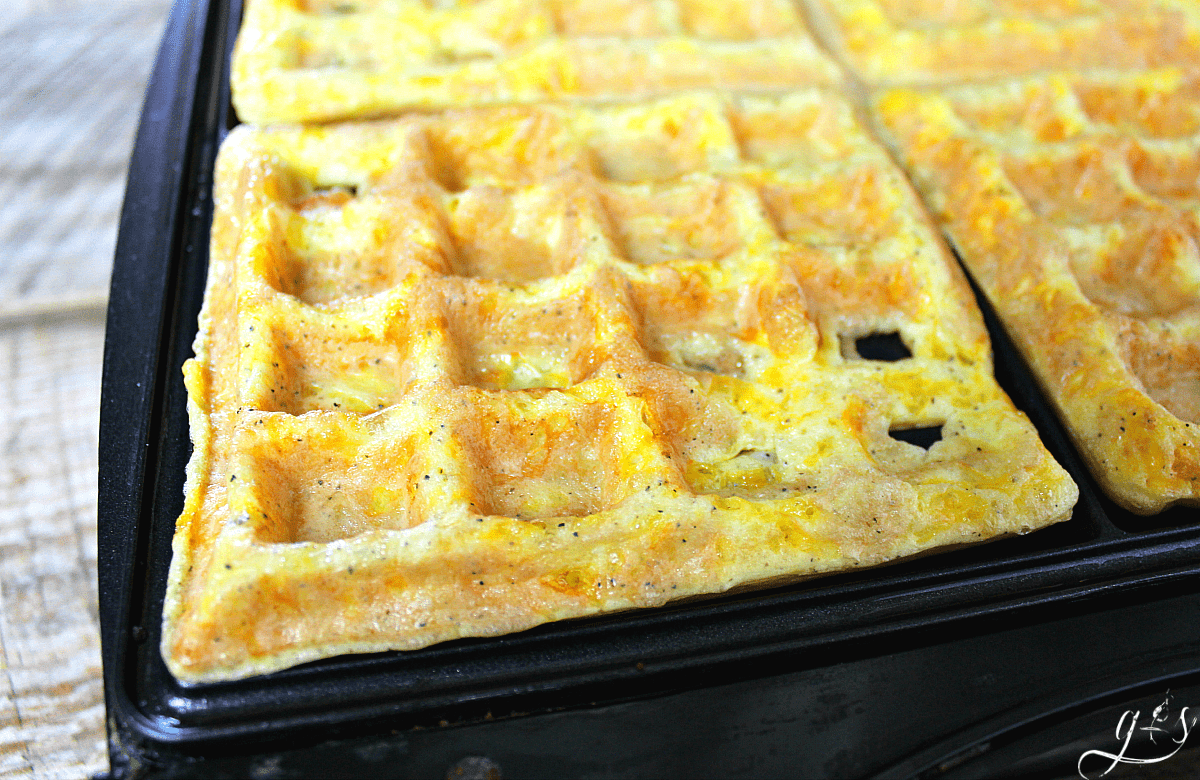 a close up of scrambled egg waffles in the waffle maker.