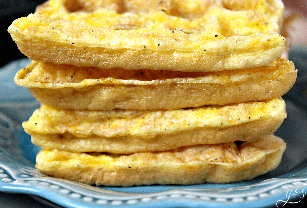 Fluffy clean eating egg waffles stacked on a blue plate.