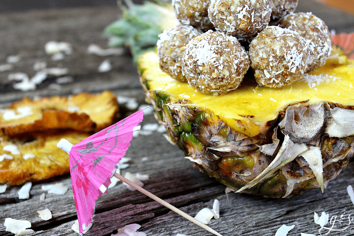The BEST 4 Ingredient Pina Colada Energy Bites | This easy no bake recipe will become your favorite healthy snack, they taste just as dreamy as the cocktail drinks! Gluten-free dried pineapple, almonds, coconut, and vanilla combine to create a clean eating, Paleo, 21 Day Fix & Whole30 approved, and vegan non-alcoholic recipe that is perfect for kids and adults alike. Take on your next trip to the beach, hike, or pack for lunch! If serving only adults, add a little rum to the mixture! 
