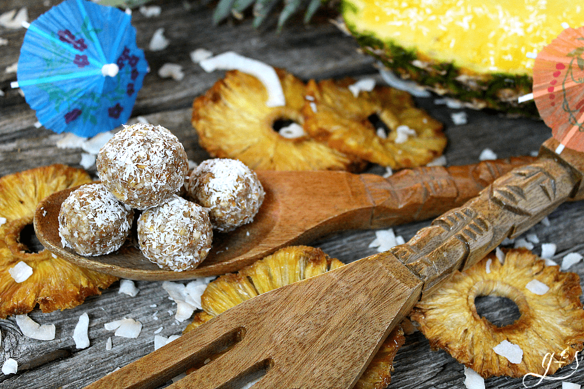 The BEST 4 Ingredient Pina Colada Energy Bites | This easy no bake recipe will become your favorite healthy snack, they taste just as dreamy as the cocktail drinks! Gluten-free dried pineapple, almonds, coconut, and vanilla combine to create a clean eating, Paleo, 21 Day Fix & Whole30 approved, and vegan non-alcoholic recipe that is perfect for kids and adults alike. Take on your next trip to the beach, hike, or pack for lunch! If serving only adults, add a little rum to the mixture! 