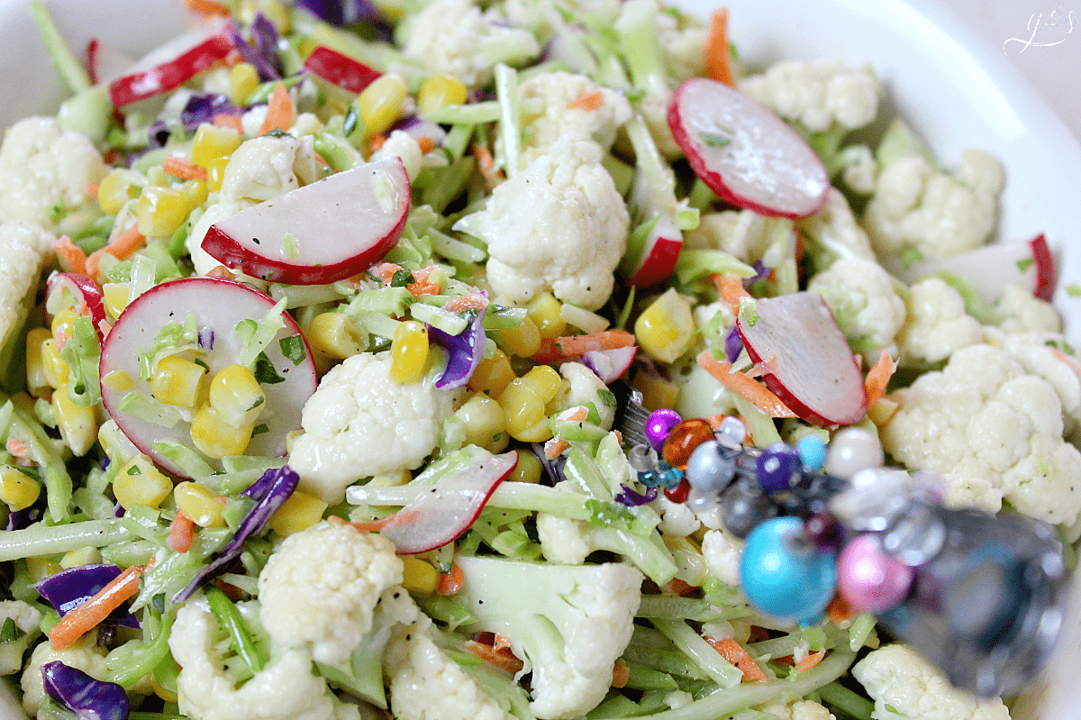 The BEST Cauliflower & Broccoli Slaw Salad | Say hello to the newest healthy and gluten free salad and homemade dressing recipes on the block! Add fresh radish and corn(fresh or frozen) to the main ingredients. Then a little clean eating mayo, fresh chopped basil, and a couple other easy pantry ingredients to the sauce. Eat this as a vegetarian meal for dinner and lunch or to feed a crowd. Spring and summer are my favorite seasons to eat this low carb and vegan side salad!