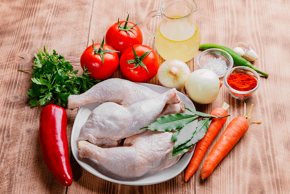 All the ingredients needed for chakhokhbili on a wooden countertop.