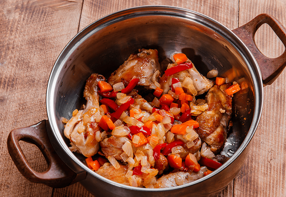 Browned chicken meat with sautéed vegetables in a large soup pot for chakhokhbili.