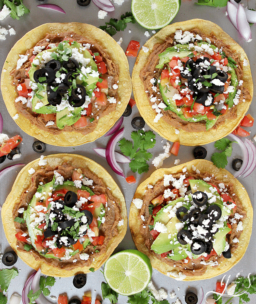 Overhead photo of six easy tostadas piled high with healthy toppings.