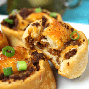 A sloppy joe crescent roll cup with a bite taken out.