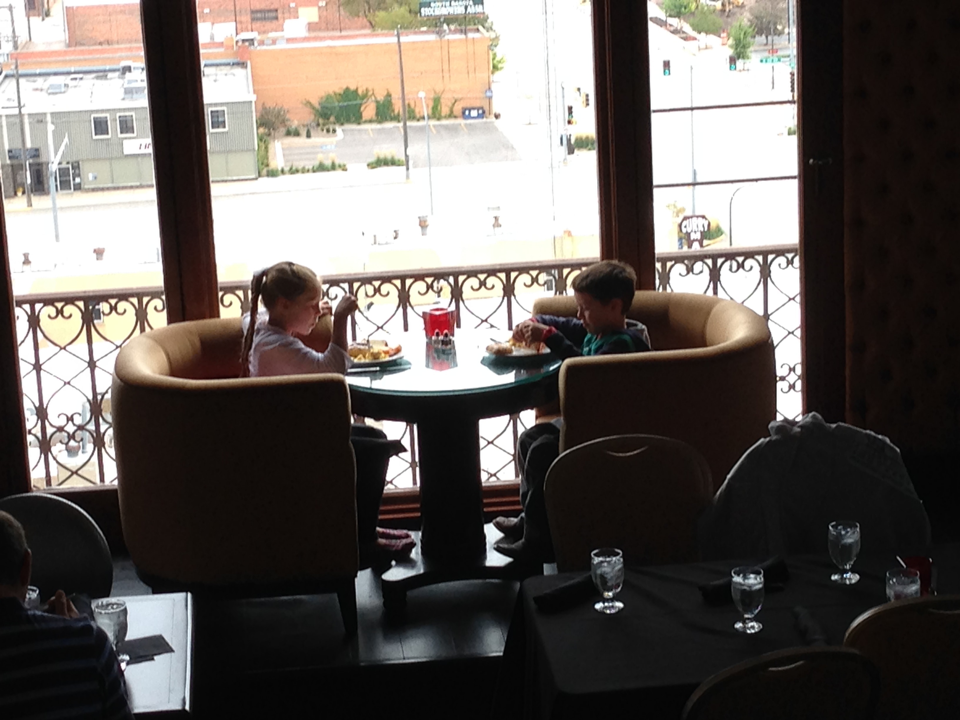 Children enjoying brunch in front of a beautiful window at a local restaurant.