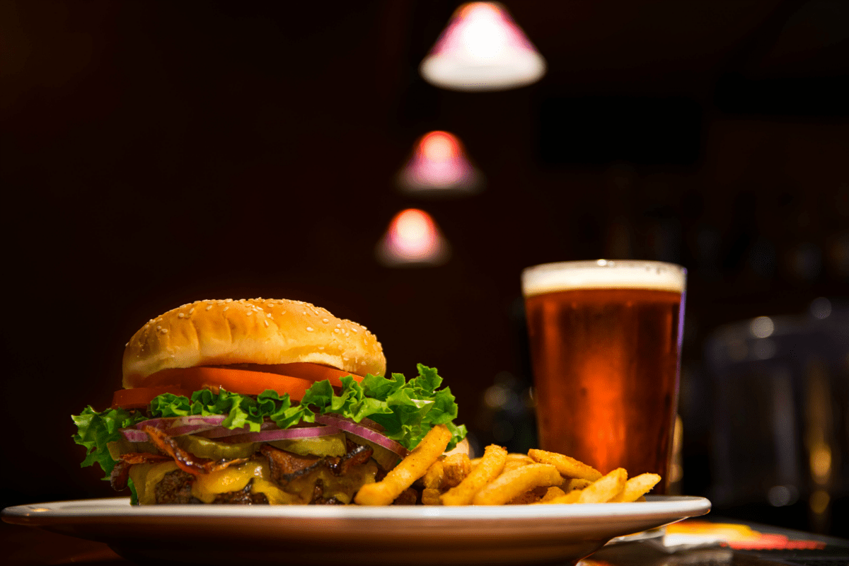 A burger and fries with a beer in the background do not help cultivate a healthy digestive system.