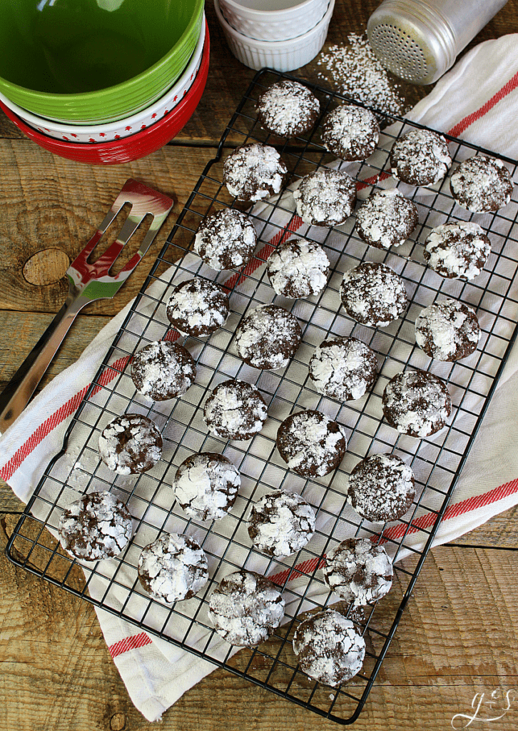 Overhead shot of holiday chocolate crinkle cookies cooling on a baking rack.
