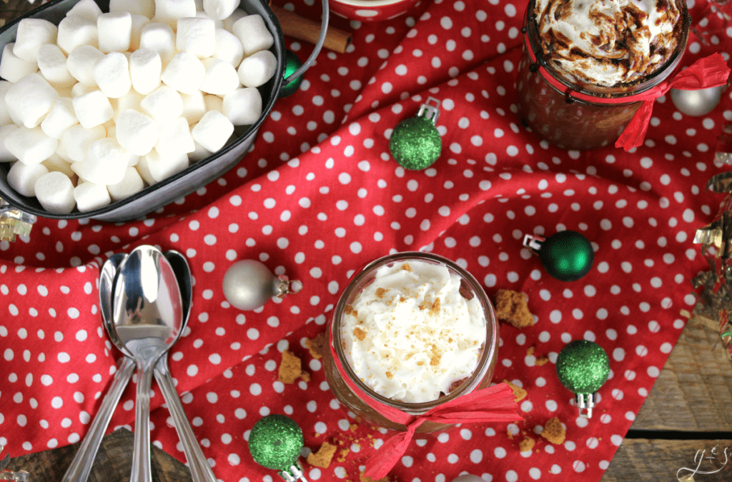 Birds eye view of marshmallows, spoons, and chocolate drink.