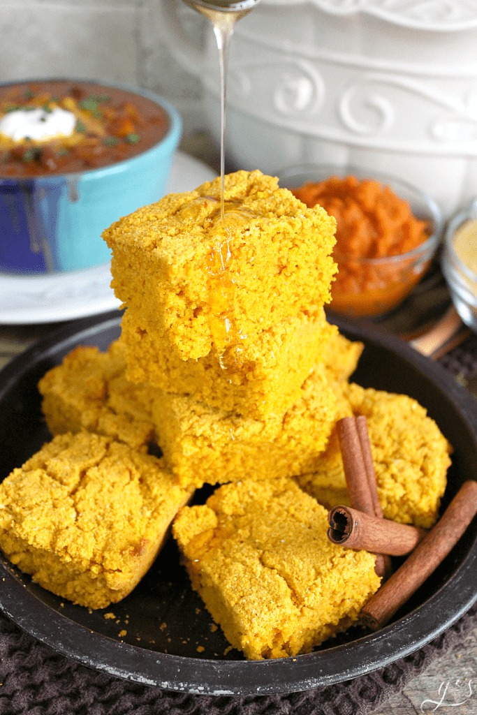 The BEST Gluten Free Pumpkin Cornbread | This easy and sweet clean eating recipe will make all your dreams come true this fall! Top this healthy side dish with butter, honey, or maple syrup. Serve alongside soup, chili, or stew for a comforting and skinny meal. You can easily make this batter into muffins too! 