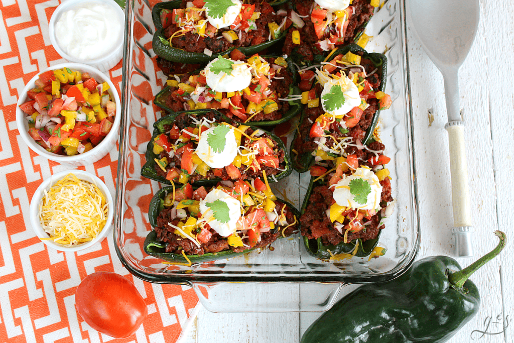 The BEST Clean Eating Stuffed Poblano Peppers | This easy Mexican dinner is healthy, gluten-free, low carb, and keto friendly. Use any ground meat (beef, buffalo, turkey, venison), shredded cheese, and top with a fresh homemade bell pepper salsa. Think of these as a healthy take on tacos by adding plain Greek yogurt (sour cream), avocado, and additional salsa to this delicious recipe. Make Paleo by omitting the cheese or use beans in place of the meat to make it vegetarian!