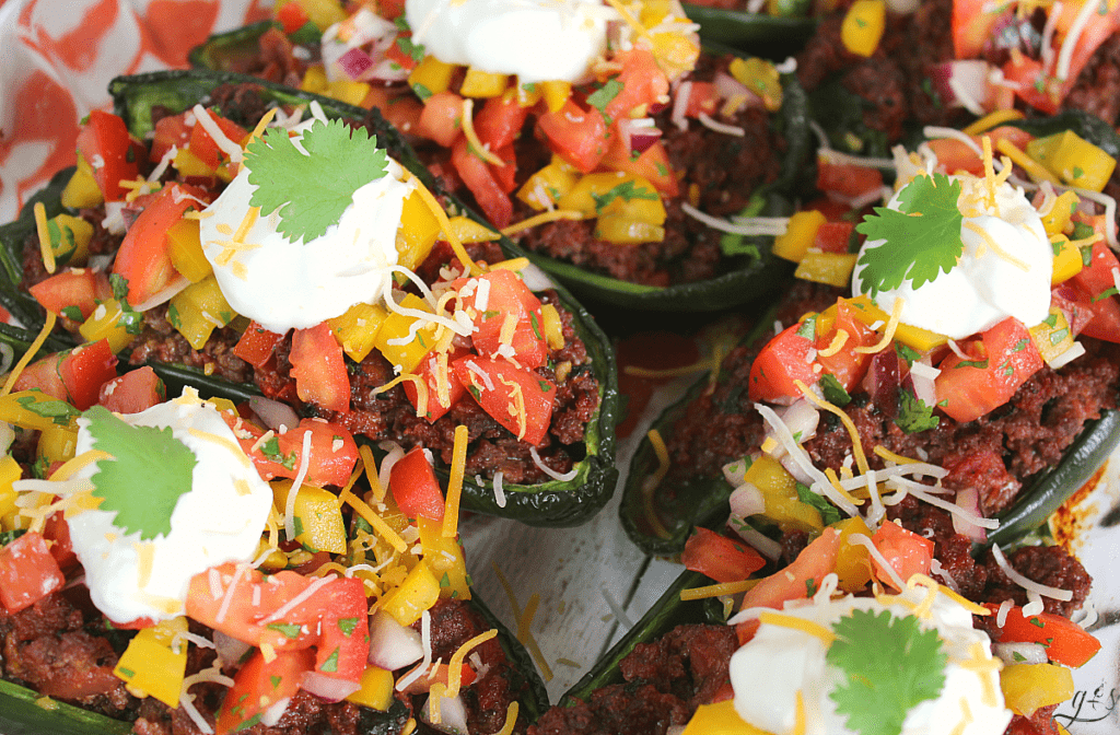 The BEST Clean Eating Stuffed Poblano Peppers | This easy Mexican dinner is healthy, gluten-free, low carb, and keto friendly. Use any ground meat (beef, buffalo, turkey, venison), shredded cheese, and top with a fresh homemade bell pepper salsa. Think of these as a healthy take on tacos by adding plain Greek yogurt (sour cream), avocado, and additional salsa to this delicious recipe. Make Paleo by omitting the cheese or use beans in place of the meat to make it vegetarian!