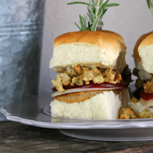 Leftover Thanksgiving sandwiches on a plate with stuffing, cranberry sauce and buns.