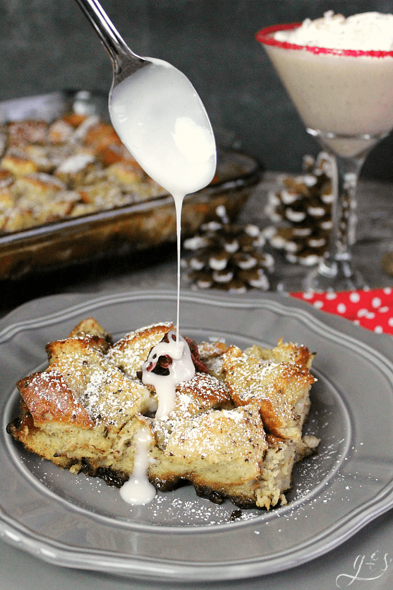 A spoon dripping glaze on top of a slice of french toast casserole.