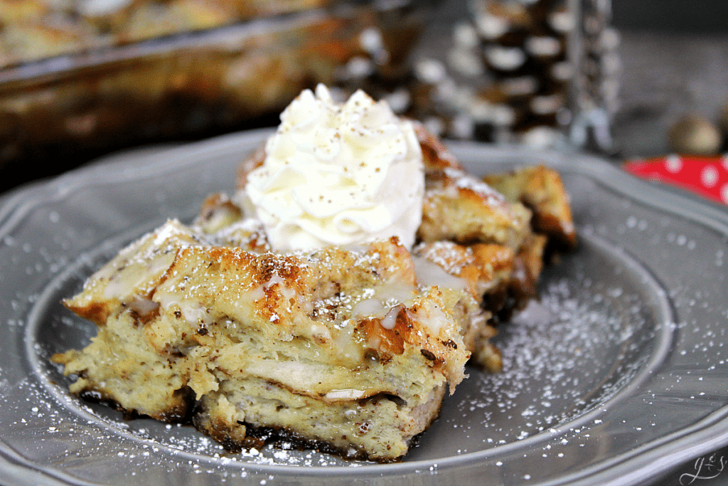 French toast bake with whipped cream on top on a grey plate. 