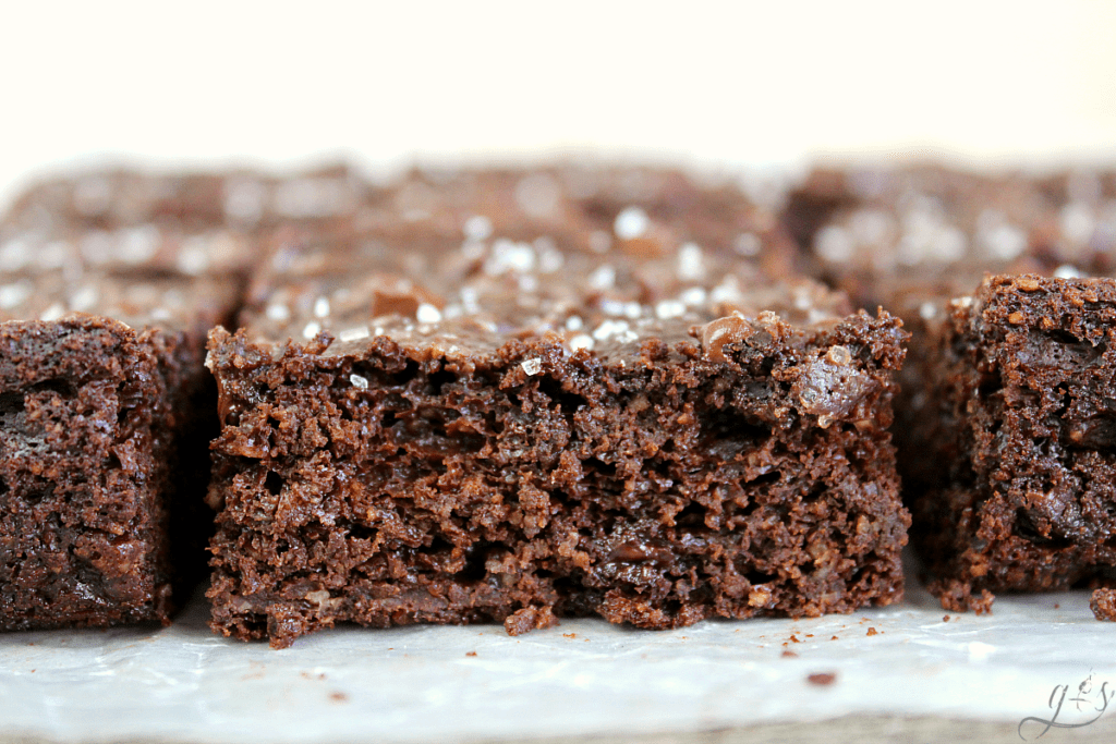 Up close view of flourless Greek yogurt brownies sprinkled with flaked sea salt. 