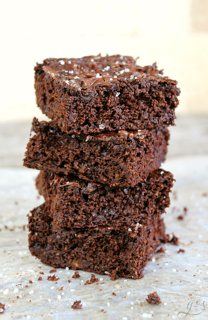The BEST Skinny Salted Fudge Brownies | This easy from scratch recipe is gluten free and low calorie too at only 125 calories. Homemade is always best and these chewy brownies are everything you want in a sweet clean eating treat! Fudgy goodness along with a slightly savory element from the flaked sea salt will tantalize your taste buds. There is no refined sugar (coconut sugar) and Greek yogurt (plant based yogurt if dairy free), applesauce, cocoa powder, and oat flour comprise in these!