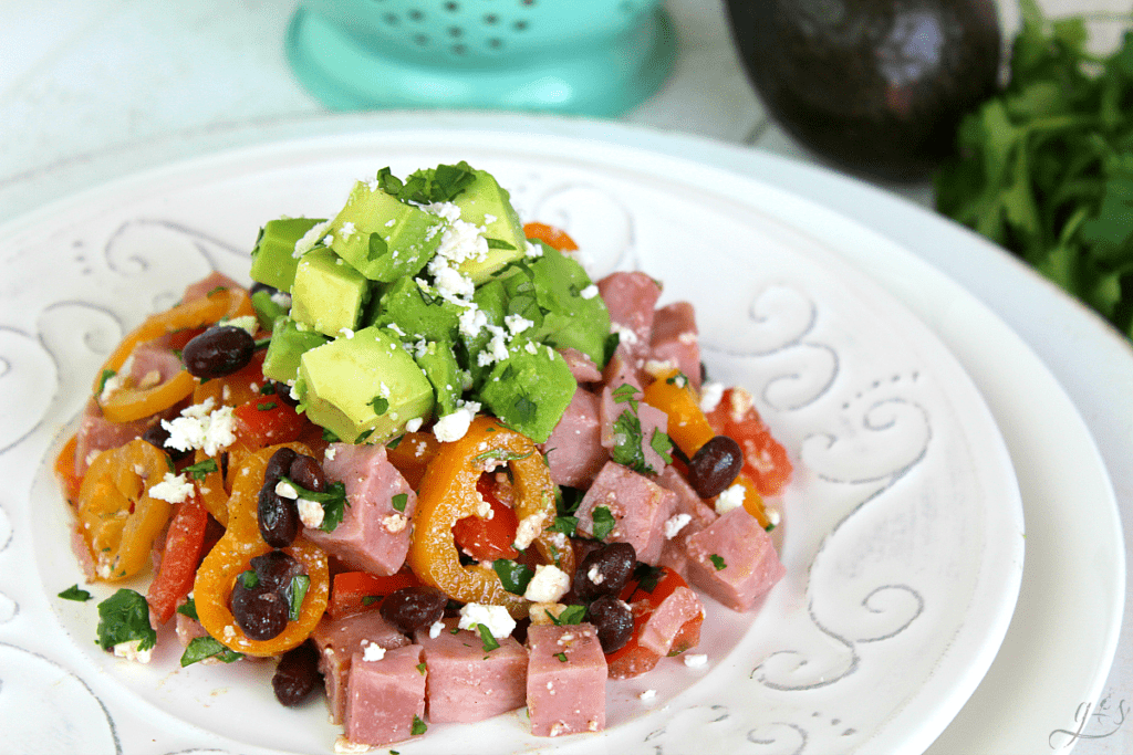 Healthy and colorful salad with ham, fresh vegetables, and black beans.