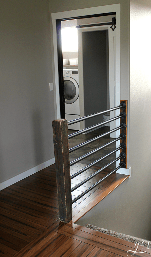 How to Build Your Own Rustic Stair Banister | Building a beautiful rustic and industrial inspired stair banister is as simple as 1-2-3. Use iron or black steel pipe, a unique wooden post (reclaimed) for newel post, and some fittings. Whether your home is classic, contemporary, or new build this antique looking banister fits well. We built this inside, but the same stairway and railings concept can be used on the porch outdoors. #farmhouse #DIY #decor