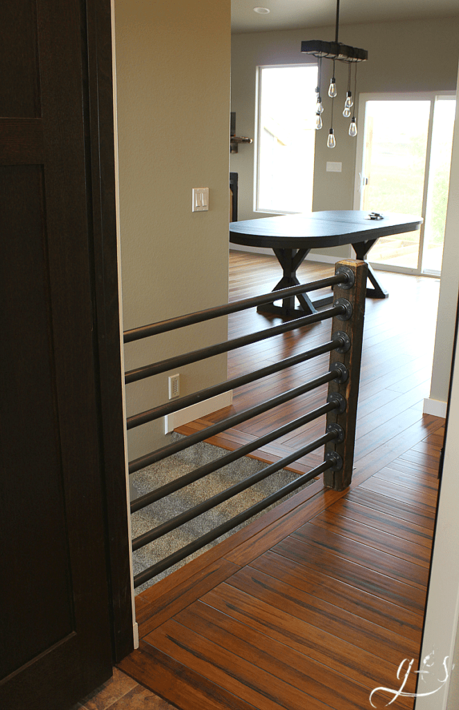 How to Build Your Own Banister | Building a beautiful rustic and industrial inspired stair banister is as simple as 1-2-3. Use iron or black steel pipe, a unique wooden post (reclaimed) for newel post, and some fittings. Whether your home is classic, contemporary, or new build this antique looking banister fits well. We built this inside, but the same stairway and railings concept can be used on the porch outdoors. #farmhouse #DIY #decor