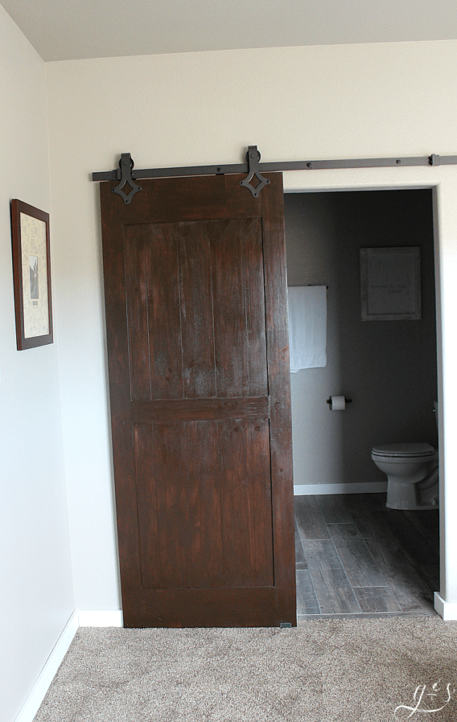 DIY Painted Barn Doors | We chose to hang two barn doors in our new home, one chalk board painted and one gel stained. You can do this project on the cheap with this tutorial. These sliding doors in our master suite and laundry room are modern yet rustic and farmhouse yet classic. The black industrial hardware and quiet floor guide work incredibly well. Plus they add so much style on a budget! #bathroom #bedroom #homedecor